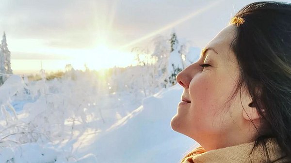 Julia Siefert Winter in winterlicher Schneelandschaft: Sie atmet tief ein - mit geschlossenen Augen genießt sie die kalte Winterluft, während sie das letzte Lichtd er untergehenden Sonne über ihr Gesicht streift - Foto: Instagram/juliasiefertwinter