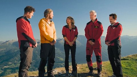 Die Bergretter stehen auf einem Bergkamm und beratschlagen sich - Foto: Screenshot/ZDF