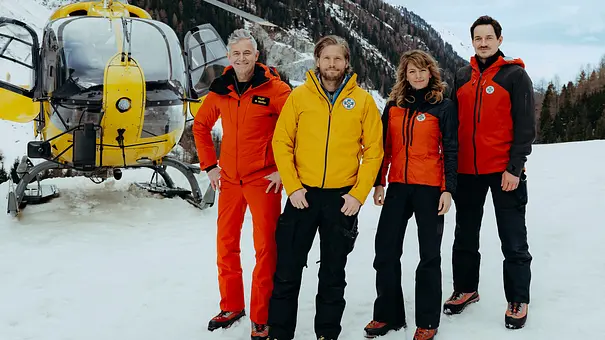 Die Bergretter: Cast steht vor einem Helikopter. - Foto: ZDF / Sabine Finger