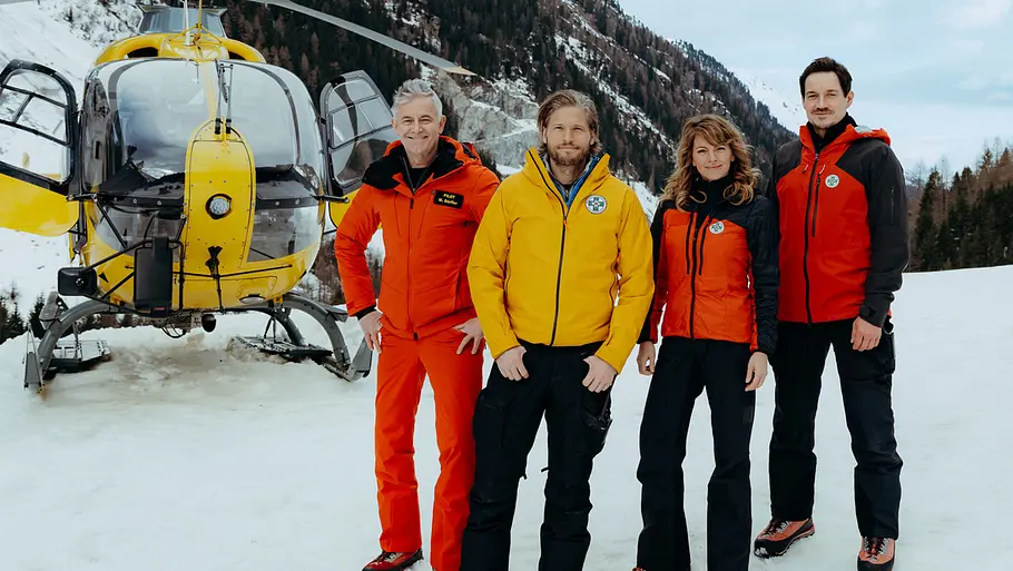 „Die Bergretter“ kehren zurück! Der Cast vom Bergretter vor einem Helikopter.