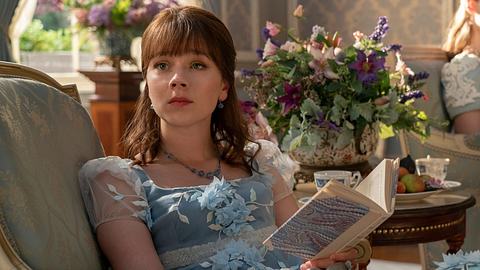 Bridgerton Eloise mit einem Buch in der Hand auf der Couch sitzend - Foto: © 2024 Netflix, Inc. LIAM DANIEL/NETFLIX