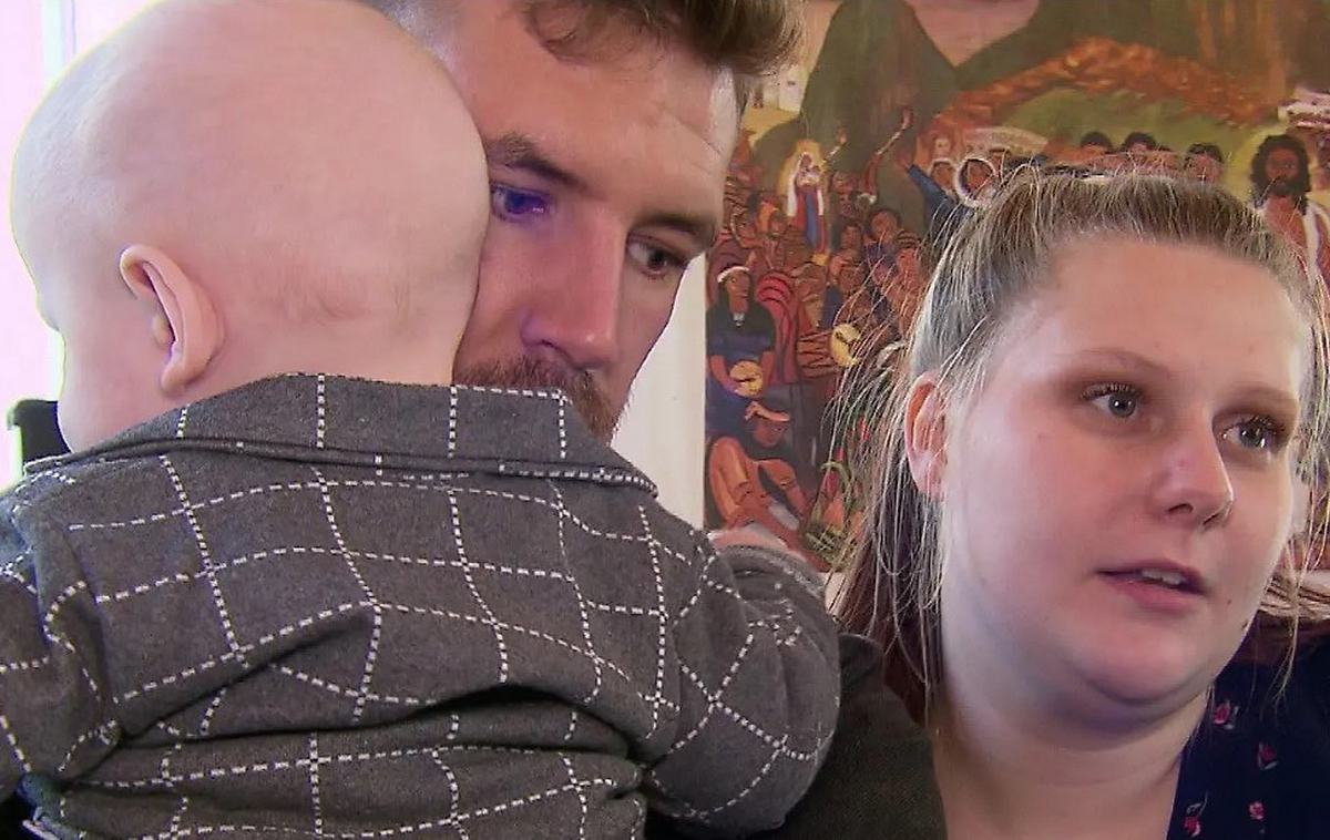 Tim Katzenbauer hält den kleinen Linus mit besorgtem Blick auf dem Arm, Ehefrau Lavinia Wollny steht daneben