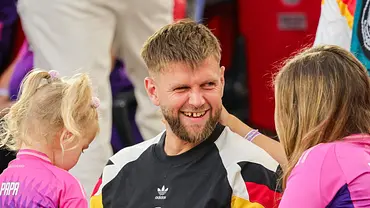 Niclas Füllkrug lachend in der Mitte, links seine Tochter Emilia, rechts seine Ehefrau Lisa, alle tragen Deutschland Trikots - Foto: dpa Niclas Füllkrug lachend in der Mitte, links seine Tochter Emilia, rechts seine Ehefrau Lisa, alle tragen Deutschland Trikots - Foto: dpa