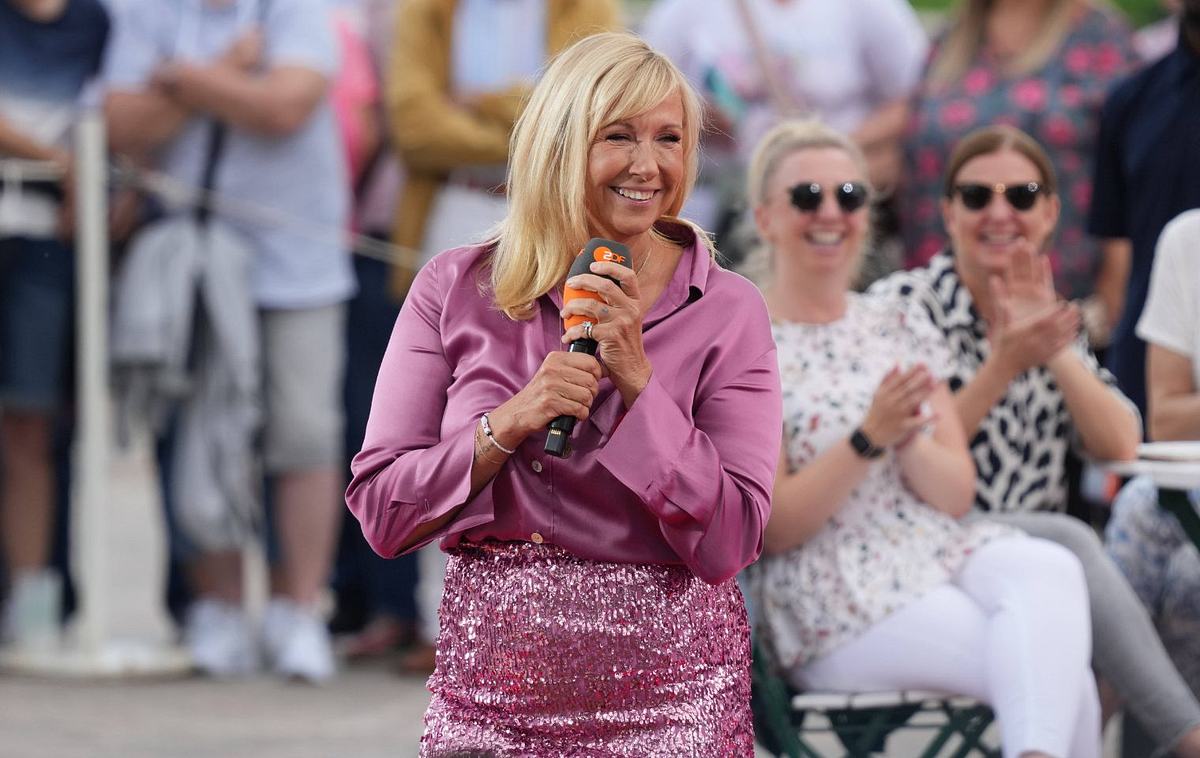 ZDF Fernsehgarten mit Andrea Kiewel Andrea Kiewel steht mit Mikrofon auf der Bühne des ZDF-Fernsehgartens am 6. Juli 2025, im Hintergrund applaudiert das Publikum bei sommerlicher Stimmung.