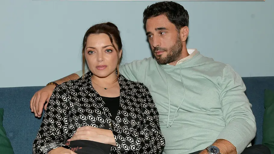 Emily und Tobias drohen eine Krise. Emily schaut ernst, während Tobias sie beobachtet.