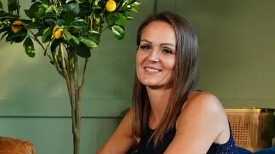 Stefanie lächelt in die Kamera. Sie sitzt vor einen grünen Wand und neben einem kleinen Zitronenbaum - Foto: Stefan Gregorowius / RTL