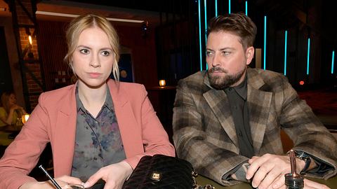 Zoe sitzt mit versteinerter Miene am Trsen, neben ihr schaur John sie ernst an. - Foto: RTL / Rolf Baumgartner