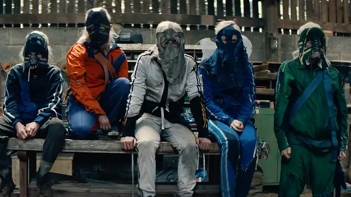 Die Jimmys, eine Bande in Sportklamotten und Masken aus dem Film „28 Years Later: The Bone Temple“ sitzen auf einem Auto.  - Foto: IMAGO / Landmark Media