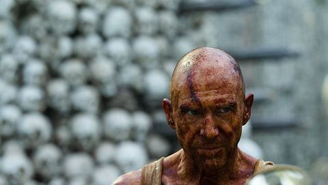 Ralph Fiennes blutverschmiert vor zahlreichen Menschenschädeln. - Foto: Media Press