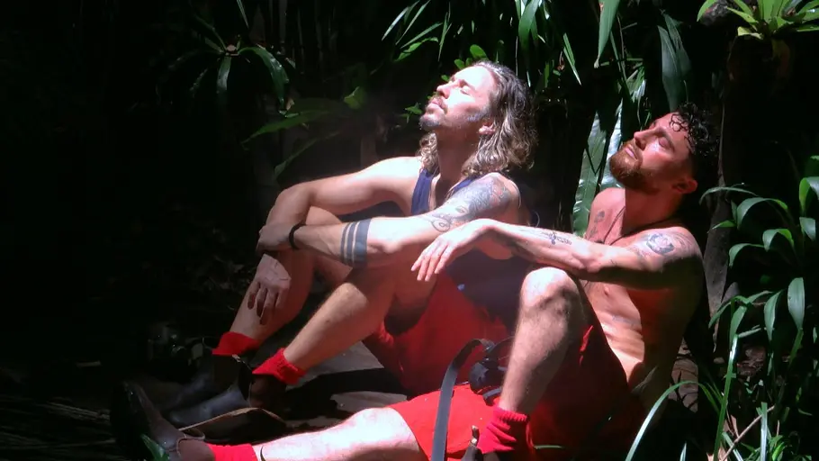 Gil und Umut genießen im Dschungelcamp die Sonne am Weiher.