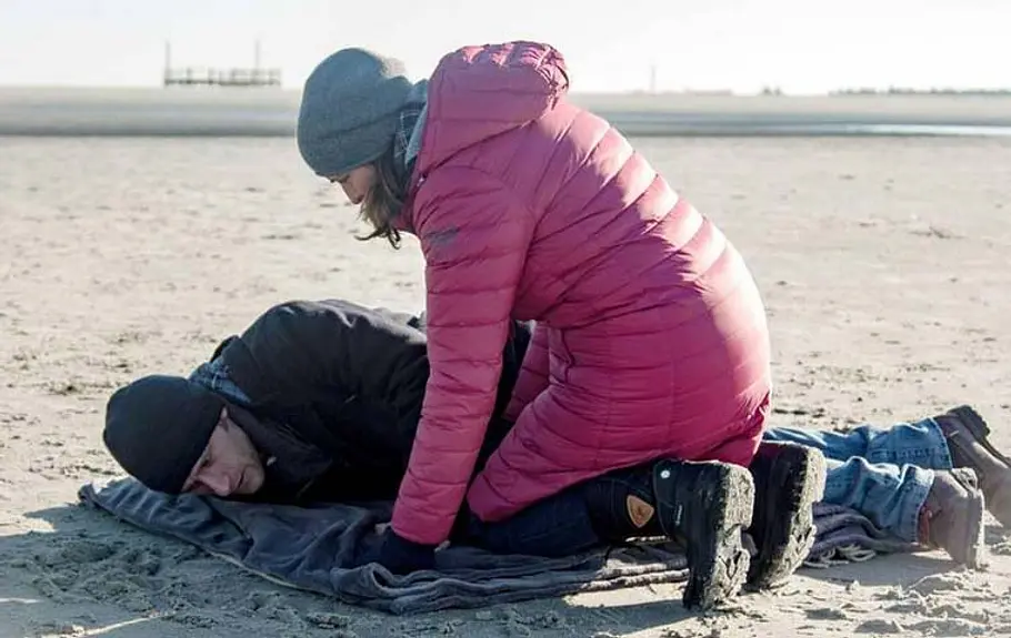 Katrin verlor ihre große Liebe Bommel. Katrin kniet am Strand vor einem regungslosen Bommel.