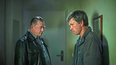 Peter Kurth (l.) und Peter Schneider stehen mit trauriger Miene in einem Flur.  - Foto: MDR/Felix Abraham