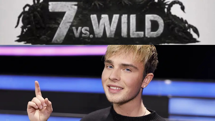 Mike Singer irritiert bei 7 vs. Wild Mike Singer trägt einen schwarzen Pullover und zeigt mit dem Zeigefinger nach oben. Über ihm steht das Logo „7 vs. Wild“.