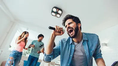 Mann singt Karaoke - Foto: iStock/Jovanmandic