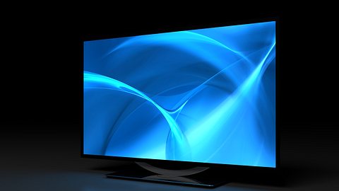 Schwarzer Flachbildfernseher mit blauem Bildschirm vor schwarzem Hintergrund - Foto: iStock/selensergen