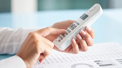 Frau mit Telefon in der Hand - Foto: iStock/eternalcreative