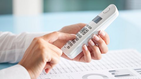 Frau mit Telefon in der Hand - Foto: iStock/eternalcreative
