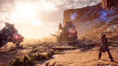 Szene aus Horizon Zero Dawn. Aloy zielt mit Pfeil und Bogen auf zwei Roboter-Tiere - Foto: Sony PlayStation/PR