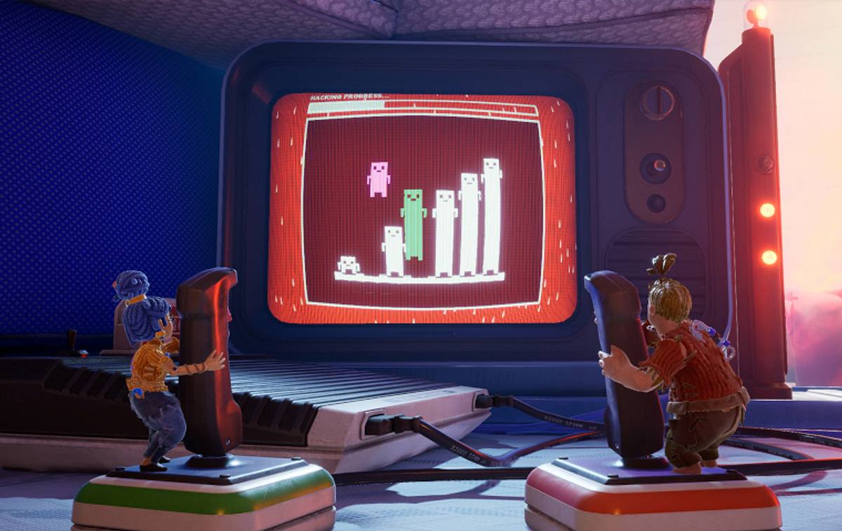 Szene aus It Takes Two: Cody und May bedienen Joysticks und spielen ein Spiel auf einem Fernseher.