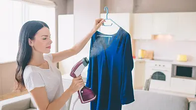 Frau mit Dampfglätter - Foto: iStock/Estradaanton