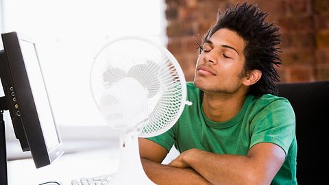 Mann mit Tischventilator - Foto: iStock/monkeybusinessimages