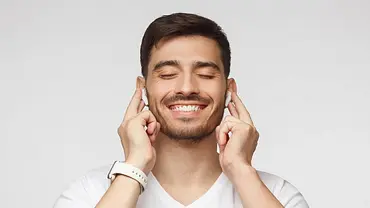 Ein Mann nutzt kabellose In-Ear-Kopfhörer. - Foto: iStock / Damir Khabirov