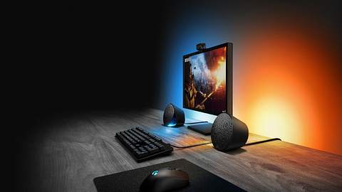 Gaming-Lautsprecher Logitech G506 auf einem Schreibtisch mit Monitor und stimmungsvollem Licht. - Foto: Logitech/PR