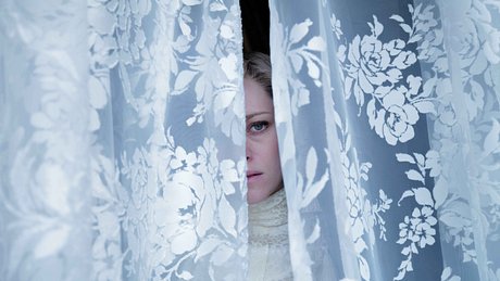 Kristen Stewart als Lady Diana blickt durch Vorhang - Foto: Pablo Larraín, DCM