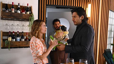Maximilian und Nathalie schauen sich tief an und Matteo hinten mit Baby. - Foto: RTL / Julia Feldhagen