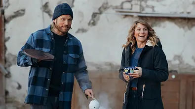Katharina und Markus lächeln, während er ihr ein Getränk einschenkt. - Foto: ZDF/Sabine Finger Fotografie
