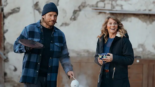 Katharina und Markus lächeln, während er ihr ein Getränk einschenkt. - Foto: ZDF/Sabine Finger Fotografie