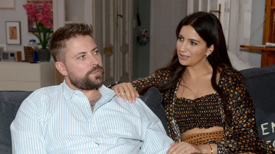 John und Laura stecken in einer Krise. John wirkt nachdenklich, während Laura ihre Hand auf seiner Schulter hat.