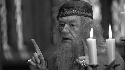 Michael Gambon als Dumbledore in Harry Potter neben brennenden Kerzen in der Großen Halle - Foto: Warner Bros.