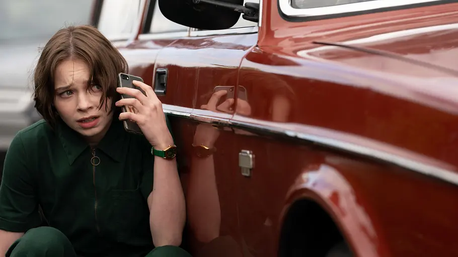 „A Good Girls Guide to Murder“ Pip versteckt sich hinter einem Auto und telefoniert panisch.