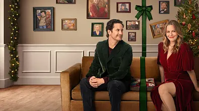 Paar sitzt auf dem Sofa welches mit einem grünen Band zweigeteilt ist - Foto: Netflix