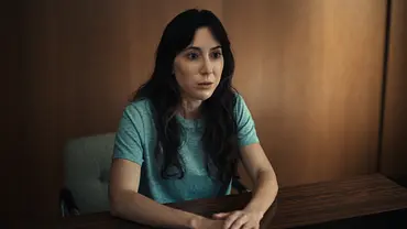 Michelle sitzt an einem Holztisch und erzählt ihre Geschichte - Foto: COURTESY OF NETFLIX Michelle sitzt an einem Holztisch und erzählt ihre Geschichte - Foto: COURTESY OF NETFLIX