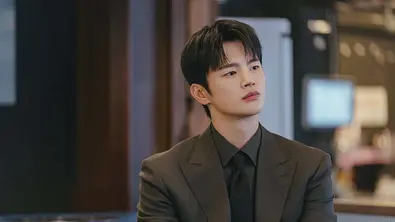Kang Si-woo sitzt in einem Meeting und hört gespannt zu. - Foto: Prime Video / tvN