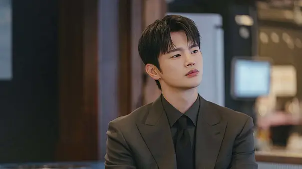 Kang Si-woo sitzt in einem Meeting und hört gespannt zu. - Foto: Prime Video / tvN