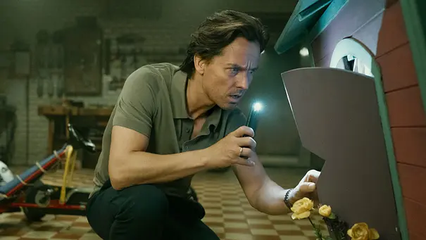 Tom Schilling schaut in einer Szene von Achtsam Morden in eine kleine Hütte. - Foto: © Anika Molnar / Netflix Tom Schilling schaut in einer Szene von Achtsam Morden in eine kleine Hütte. - Foto: © Anika Molnar / Netflix