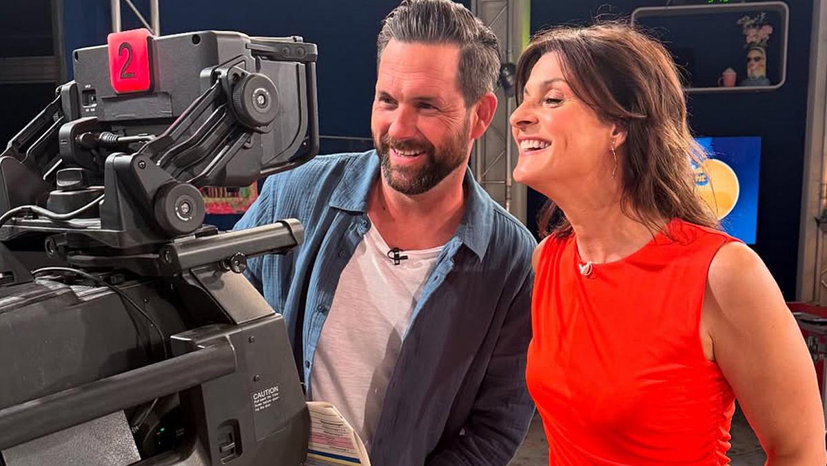 Matthias Killing und Marlene Lufen stehen während der „Sat.1-Frühstücksfernsehen“-Aufzeichnung am 4. Juni 2025 vor einer Kamera und grinsen.