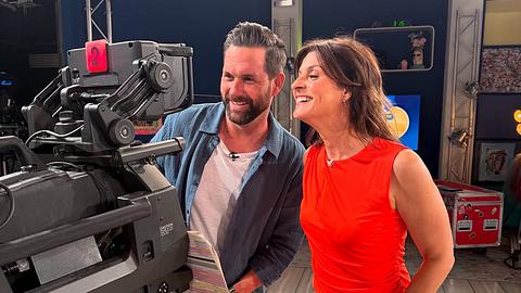 Matthias Killing und Marlene Lufen stehen während der „Sat.1-Frühstücksfernsehen“-Aufzeichnung am 4. Juni 2025 vor einer Kamera und grinsen. - Foto: Instagram.com/fruehstuecksfernsehen/