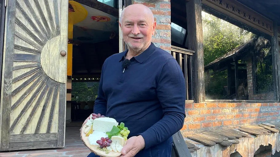 Aleksandar kommt aus Kroatien. Aleksandar mit einem Teller Käse in der Hand.