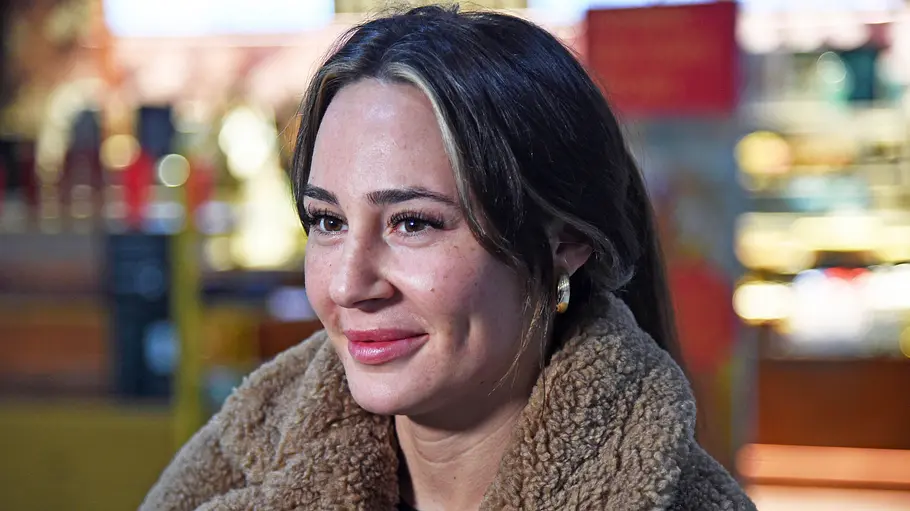 Alessia Herren Alessia Herren trägt einen Teddymantel und lächelt.