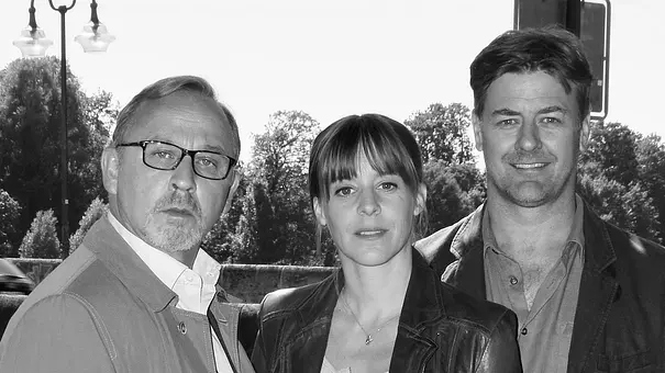 Ein Schwarz-Weiß-Foto zeigt Alexander Held, Bernadette Heerwagen und Marcus Mittermeier beim am Set des ZDF-Krimis München Mord. - Foto: IMAGO / Future Image