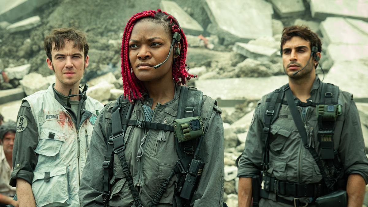 In „Alien: Earth“ stehen Alex Lawther als Hermit, Diêm Camille als Siberian, Moe Bar-El als Rashidi vor Trümmern. Die Schauspieler schauen ernst in eine Richtung!