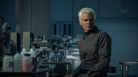 Timothy Olyphant auf einem Szenenbild zu Alien Earth schaut in einem Labor skeptisch Richtung Kamera - Foto: Disney+ / FX