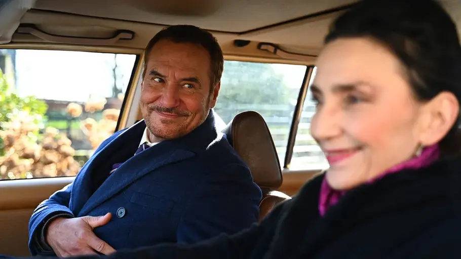 Richard und Simone sitzen im Auto. Er schaut sie sehr verliebt an.