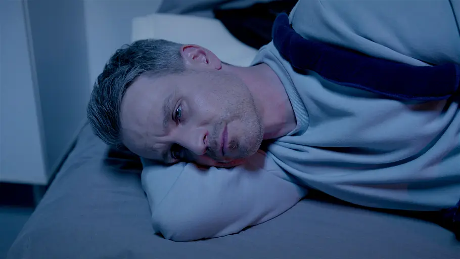 Kilian AWZ Kilian liegt auf seinem Bett und schaut traurig nach vorne.