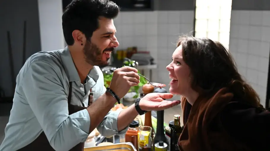 Matteo füttert Emma mit einem Löffel in der Küche des Puntos