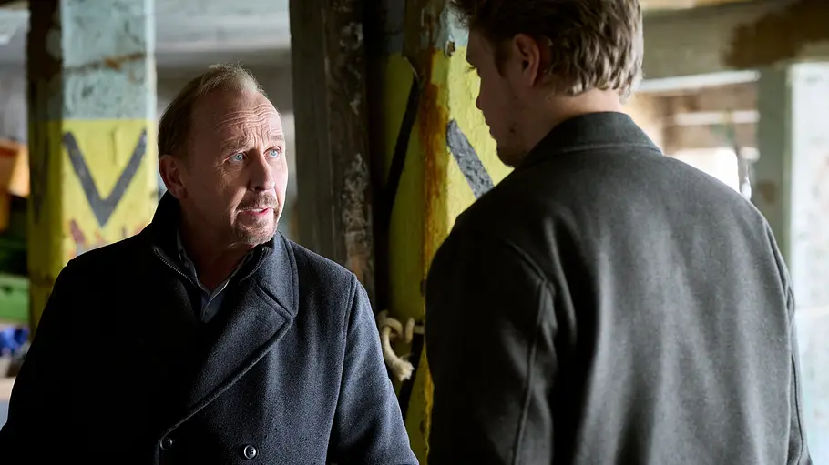 Alexander Held ist Ende Oktober ein letztes Mal als Karl Hidde zu sehen. Karl Hidde (Alexander Held) und Tomasz Nowak (Jakub Gierszal) stehen sich gegenüber und sind im Gespräch miteinander.